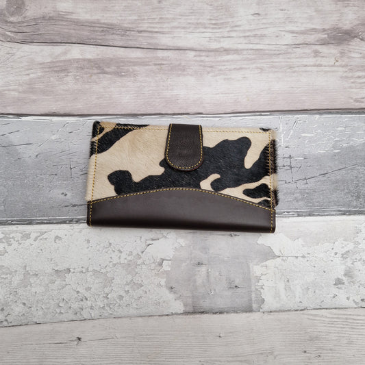 Purse made from leather off cuts featuring textured panels in a cow print.