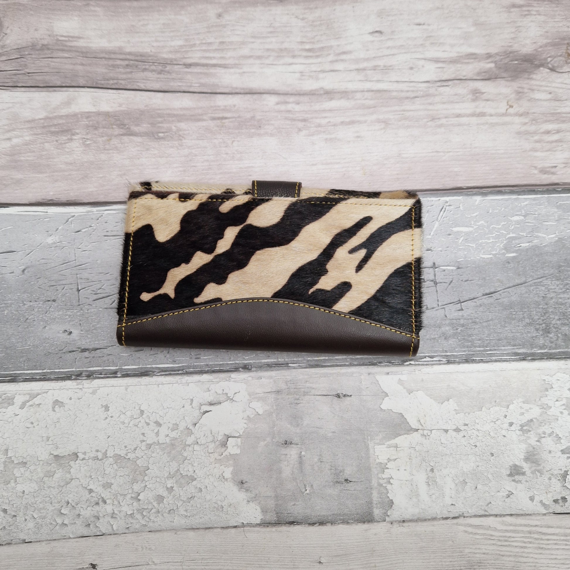 Purse made from leather off cuts featuring textured panels in a cow print.