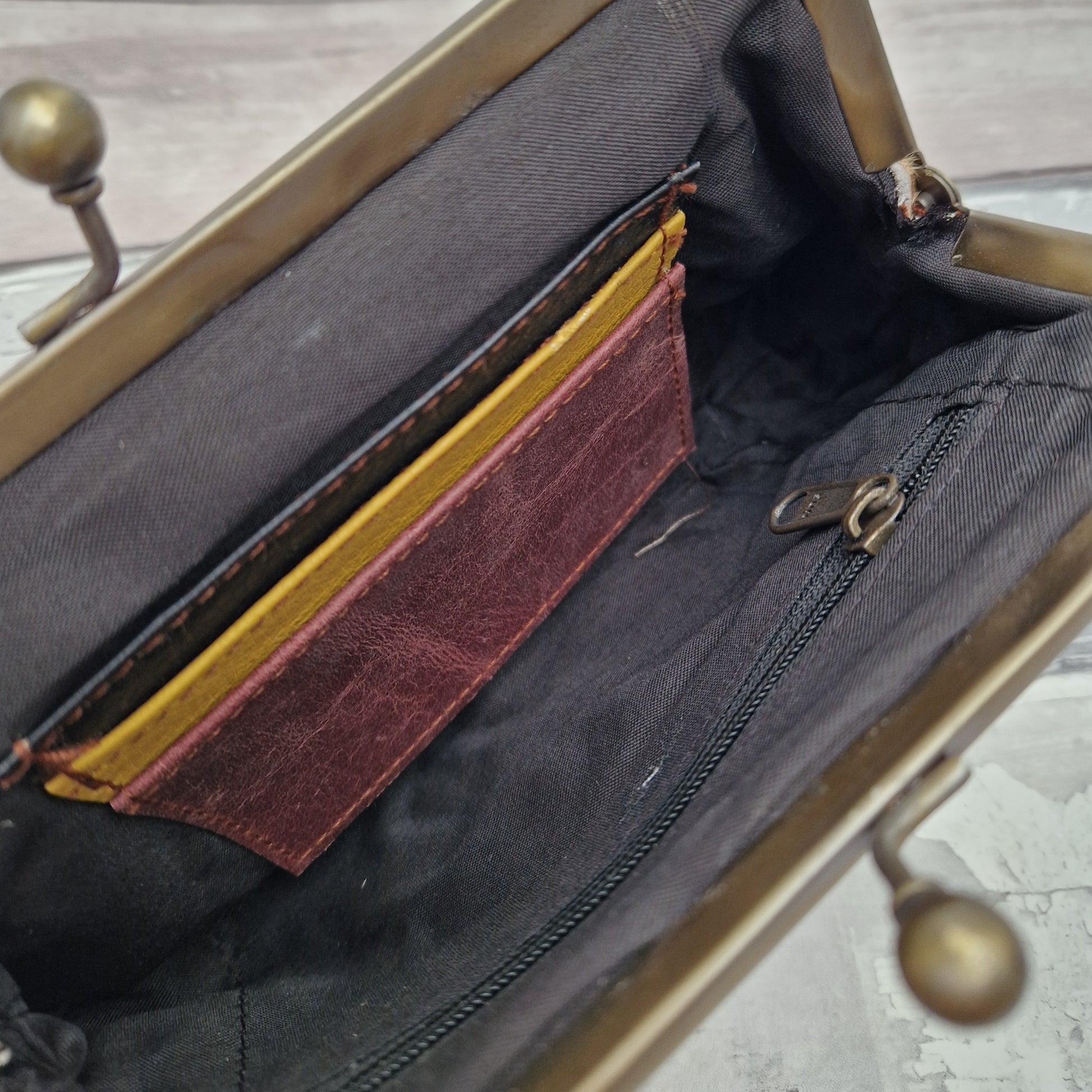 Inside of clutch bag showing zipped pocket and card slots.