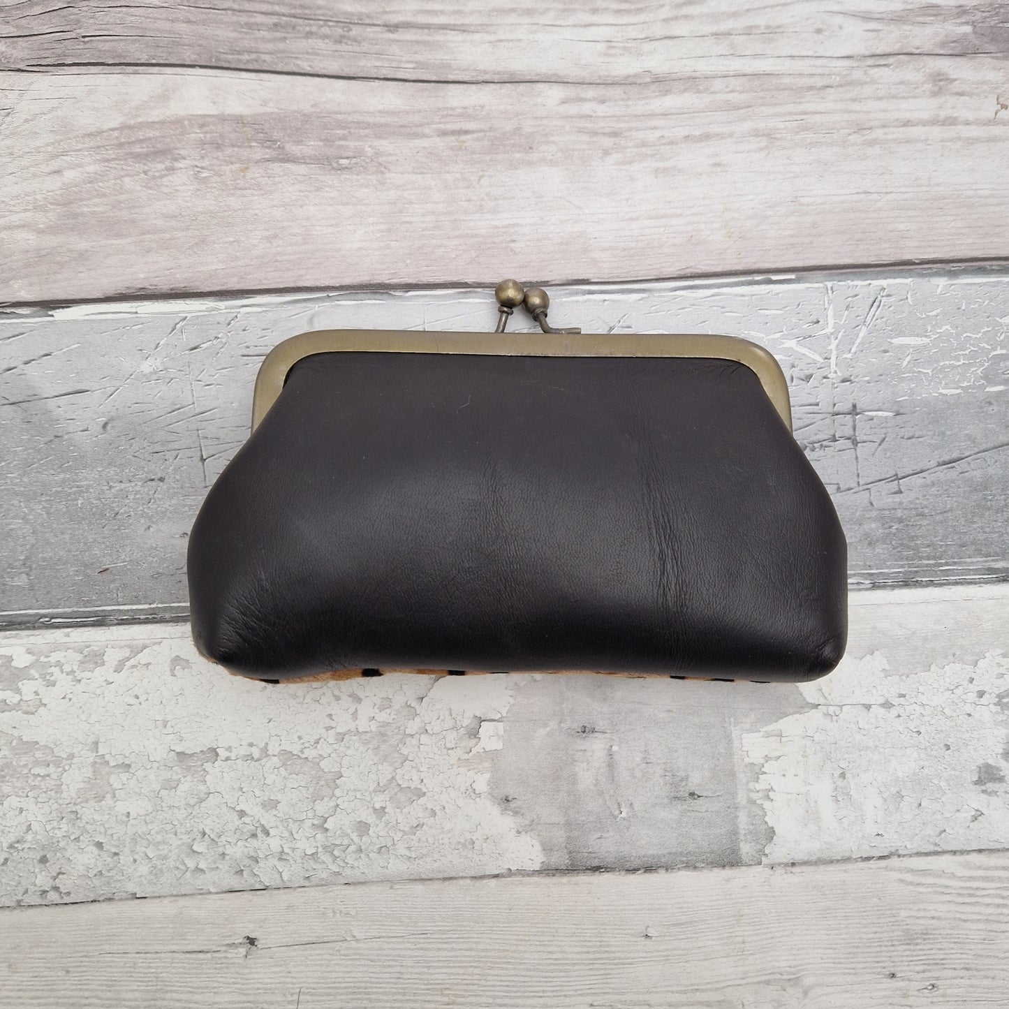 Black leather backside of clutch bag.
