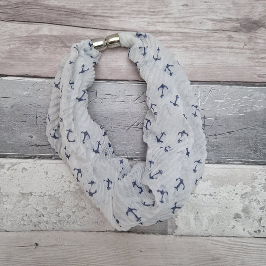 White crinkled neck scarf decorated with blue anchors.