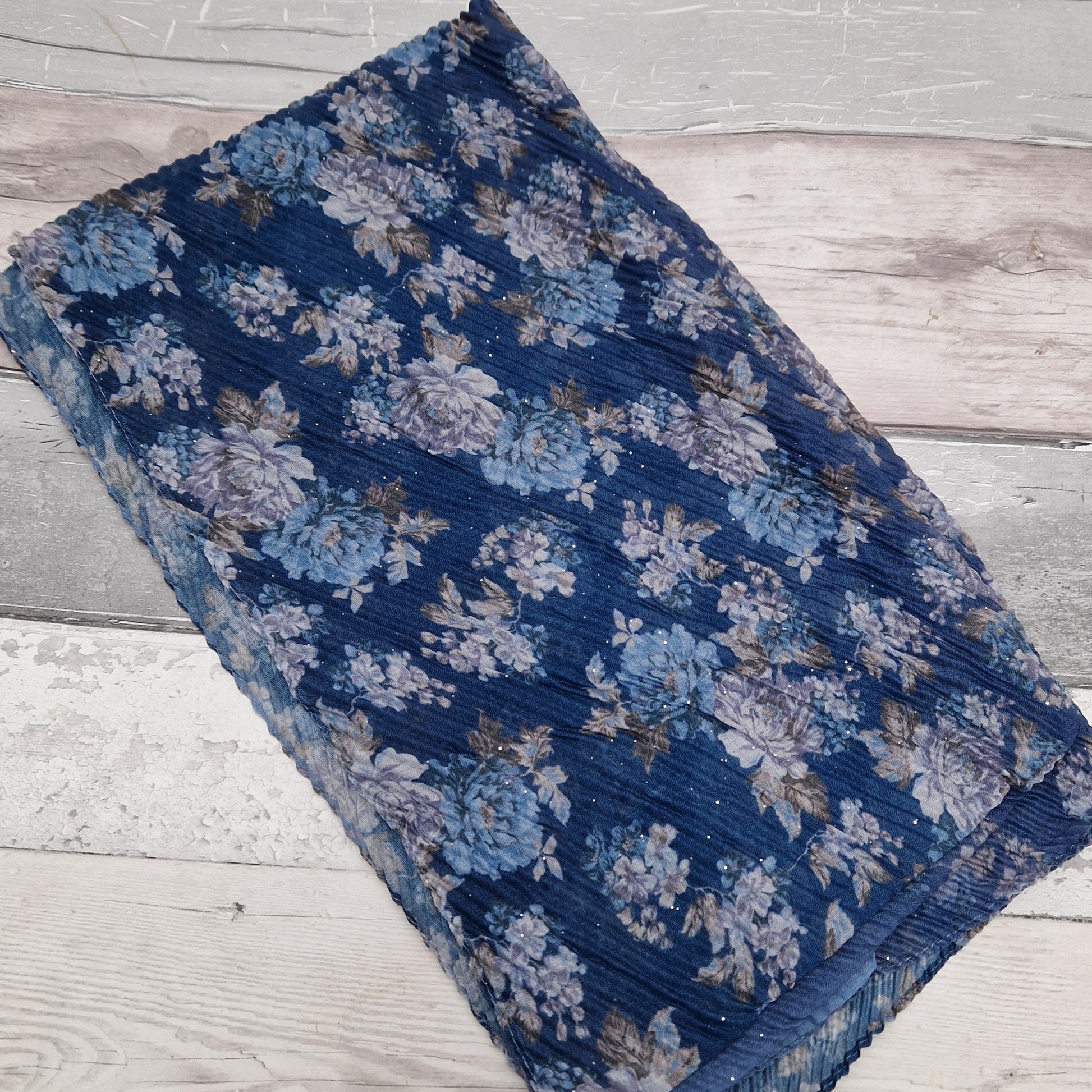 Blue toned scarf decorated with swathes of blue and climbing rose print.