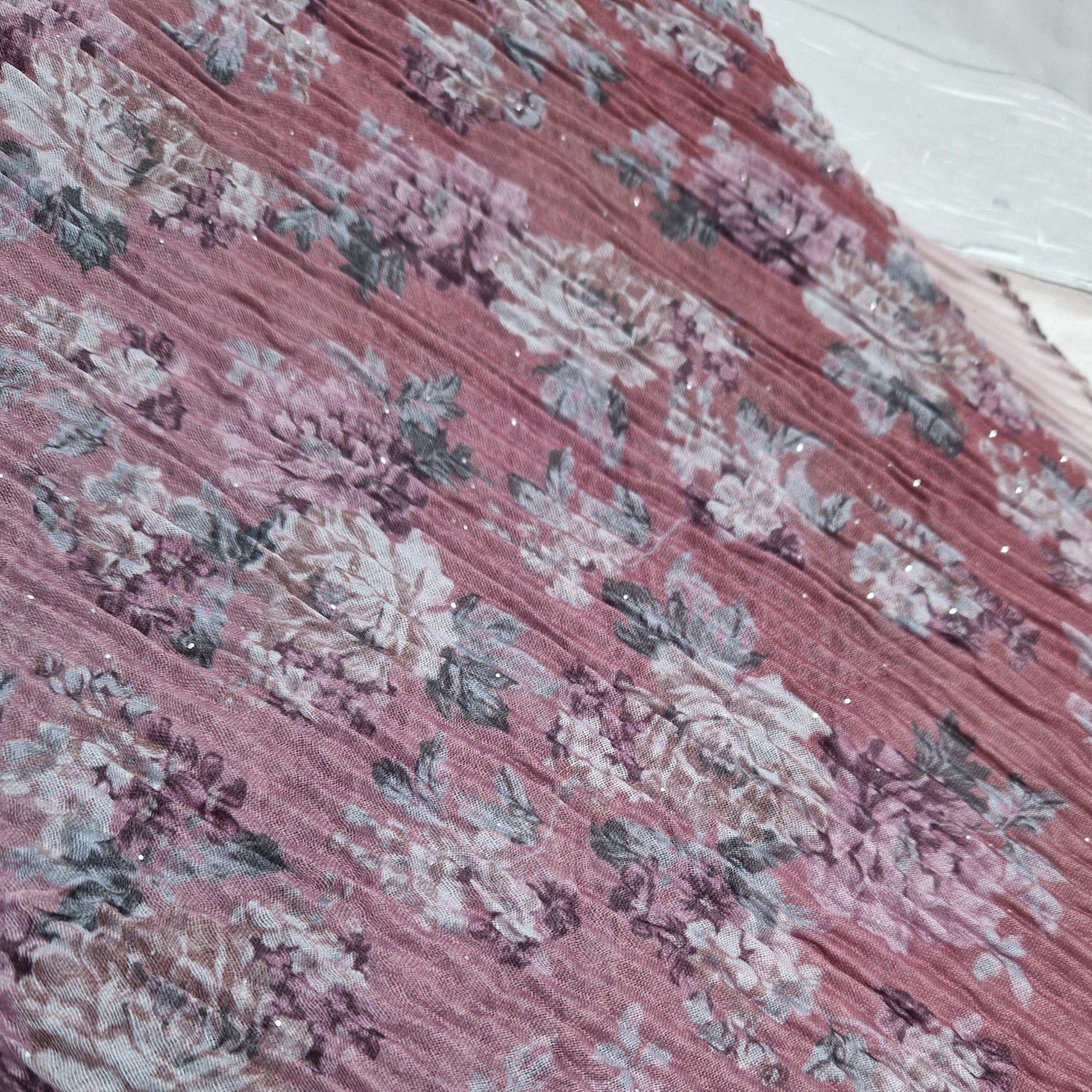 Pink toned scarf decorated with swathes of pink and climbing rose print.