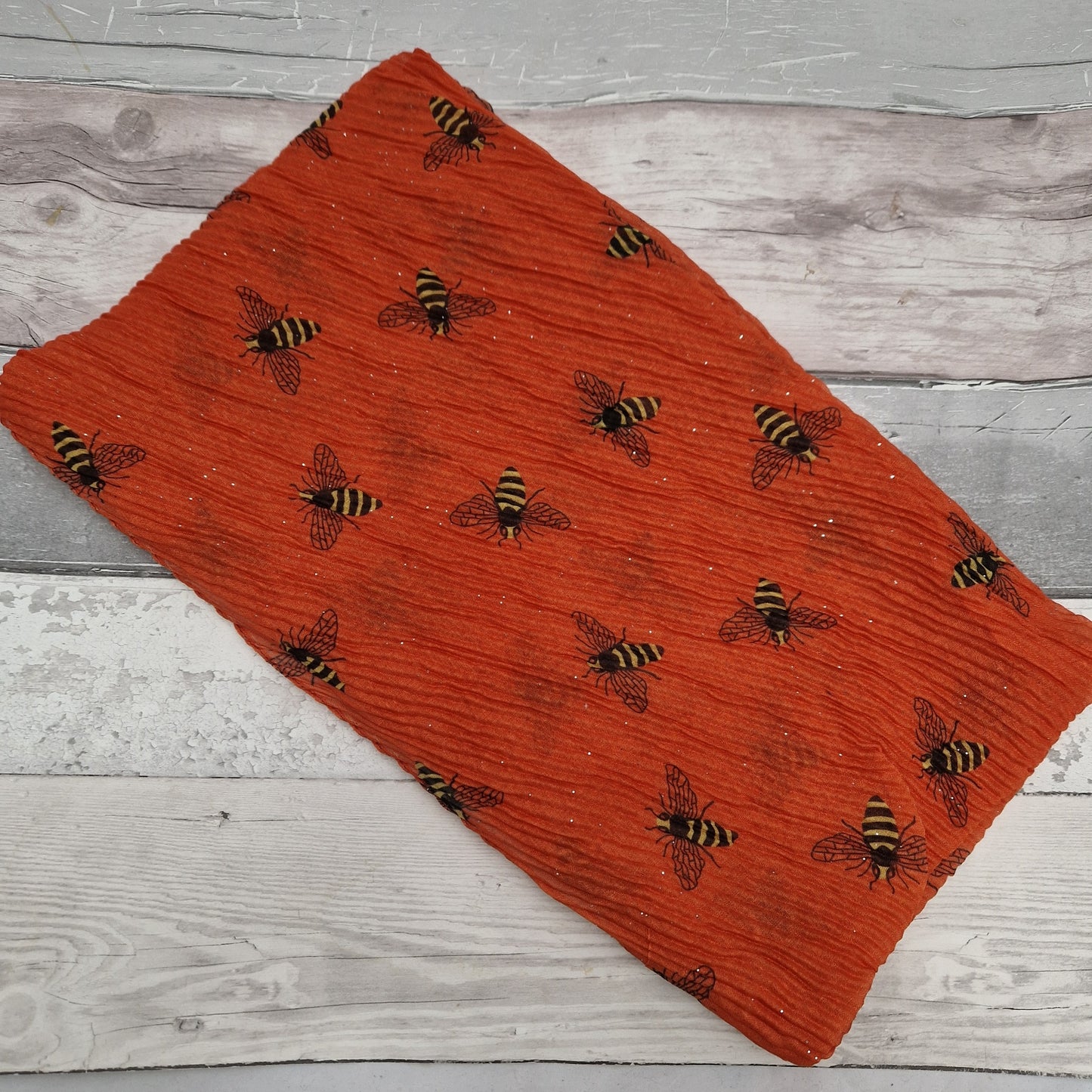 Orange scarf in a crinkle fabric featuring black and yellow bees.
