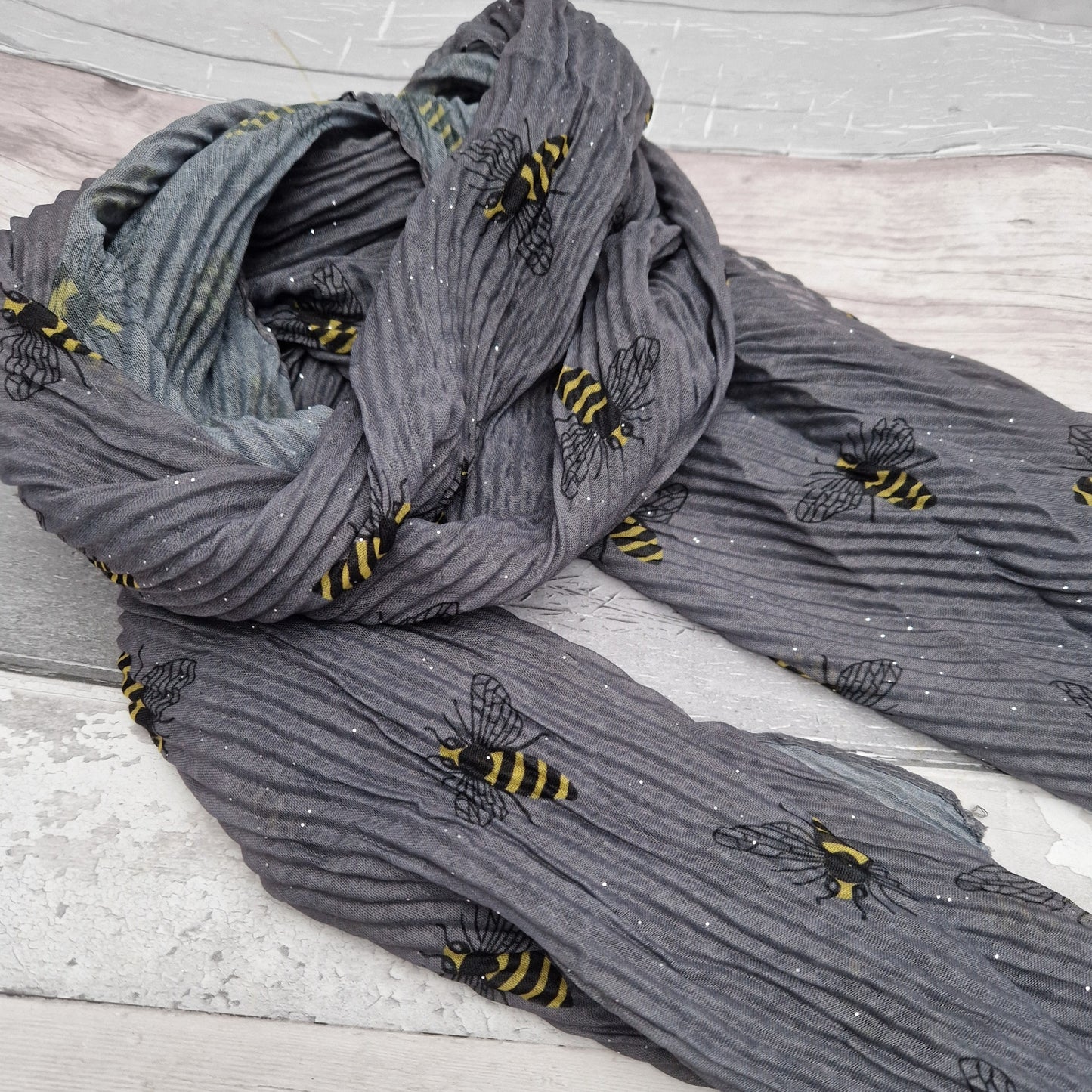 Grey scarf in a crinkle fabric featuring black and yellow bees.