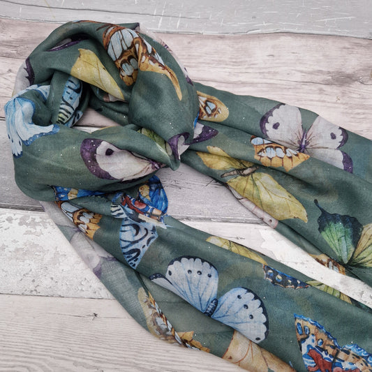 Forest green scarf decorated with a collection of vividly coloured butterflies and finished with silver sparkles.
