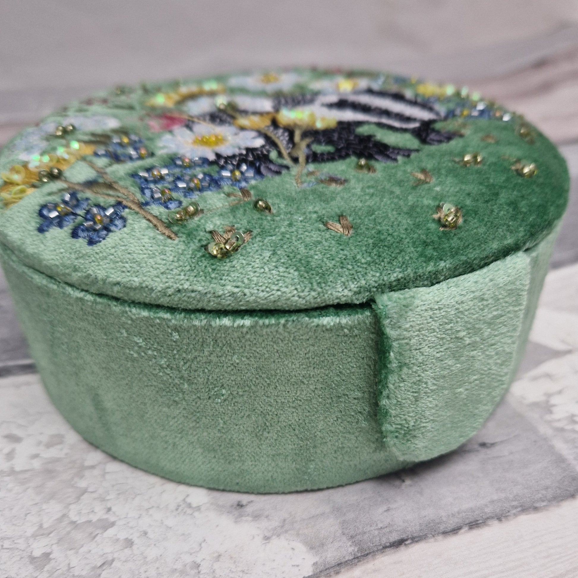 Green velvet covered jewellery box featuring an embroidered design of a Badger in a flower garden. Finished with beads and sequins.