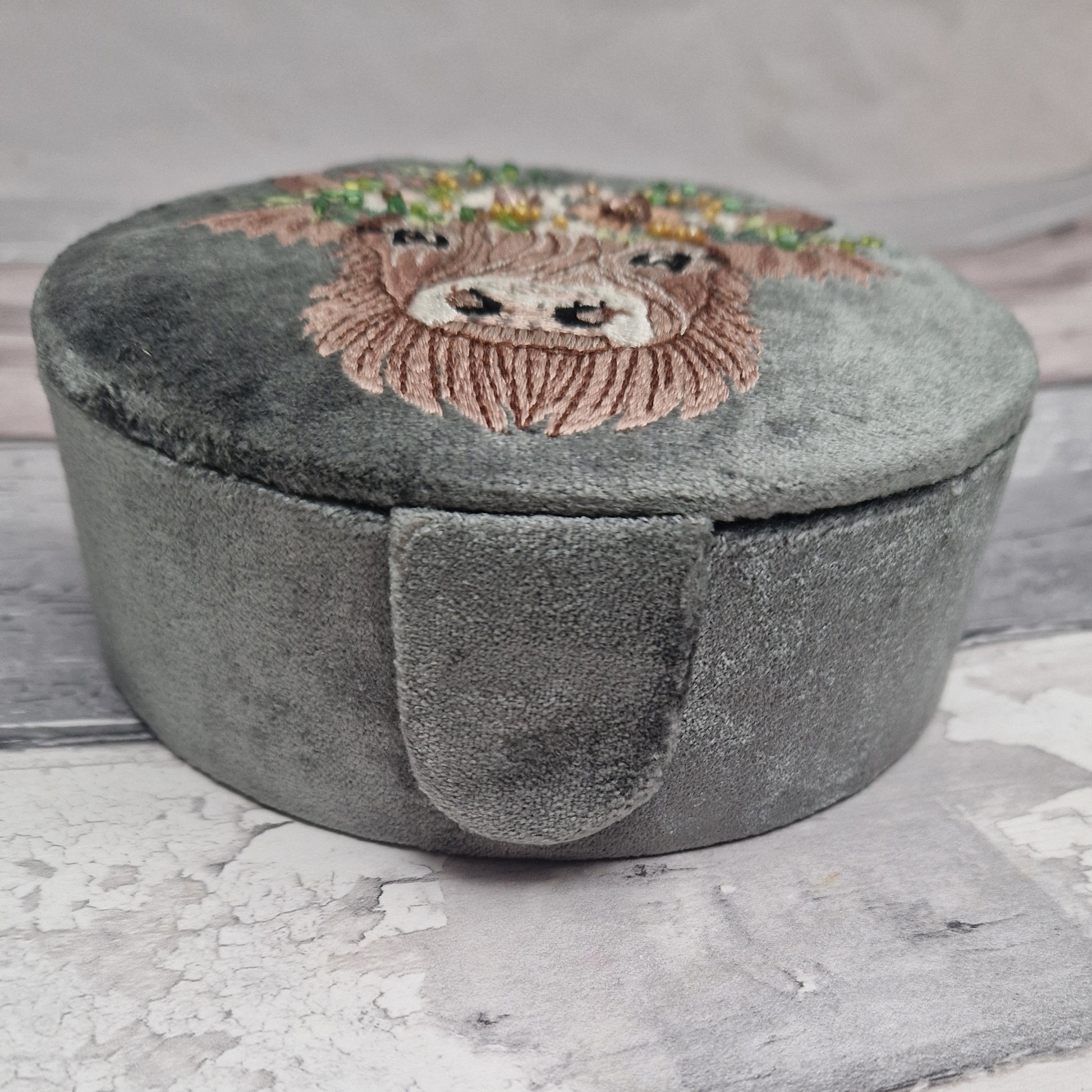Grey velvet covered jewellery box featuring an embroidered design of a Highland Cow. Finished with beads and sequins.