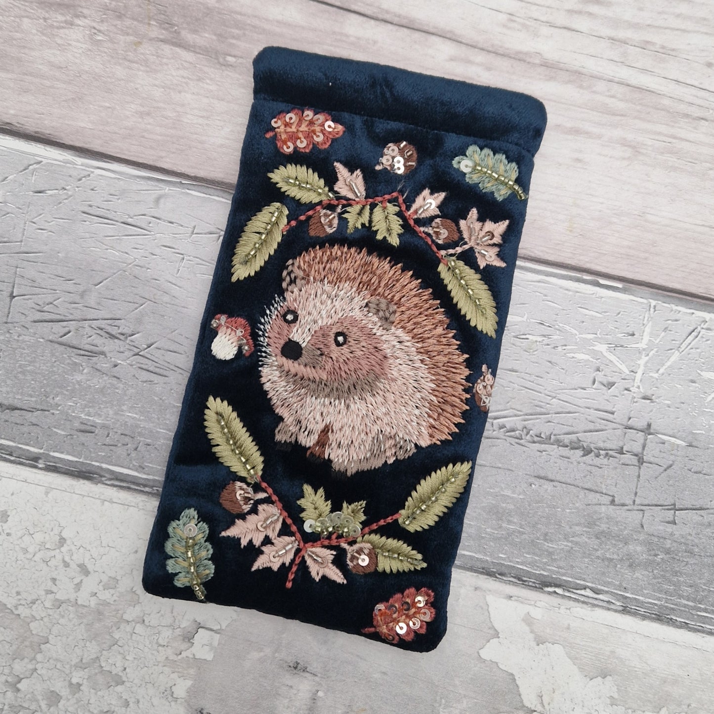 Navy velvet glasses case decorated with an embroidered Hedgehog woodland scene. Finished with beads and sequins.