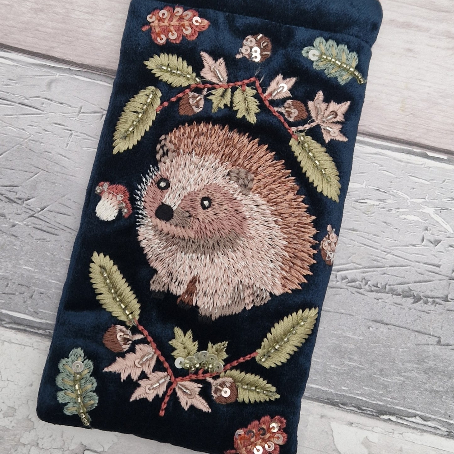 Navy velvet glasses case decorated with an embroidered Hedgehog woodland scene. Finished with beads and sequins.