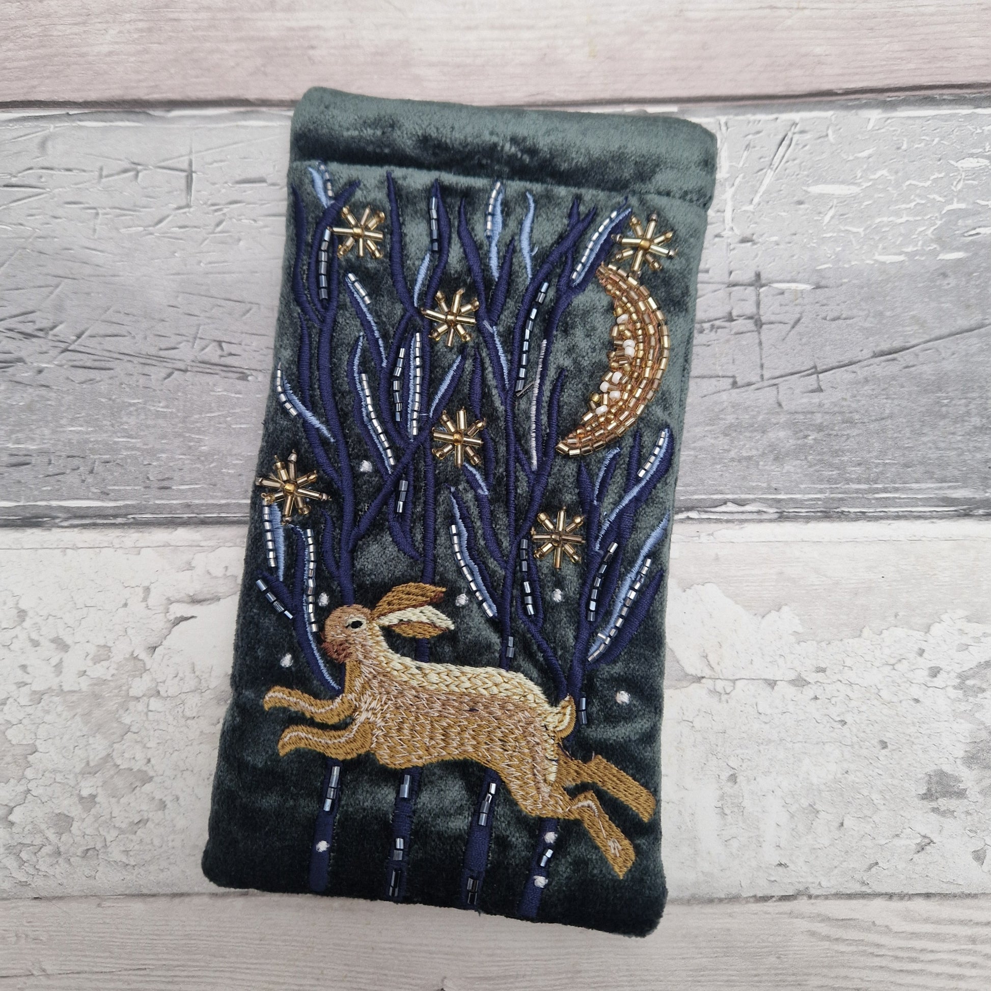 Dark grey velvet glasses case decorated with an embroidered Hare running through the woods under a crescent moon and starry night scene. Finished with beads and sequins.