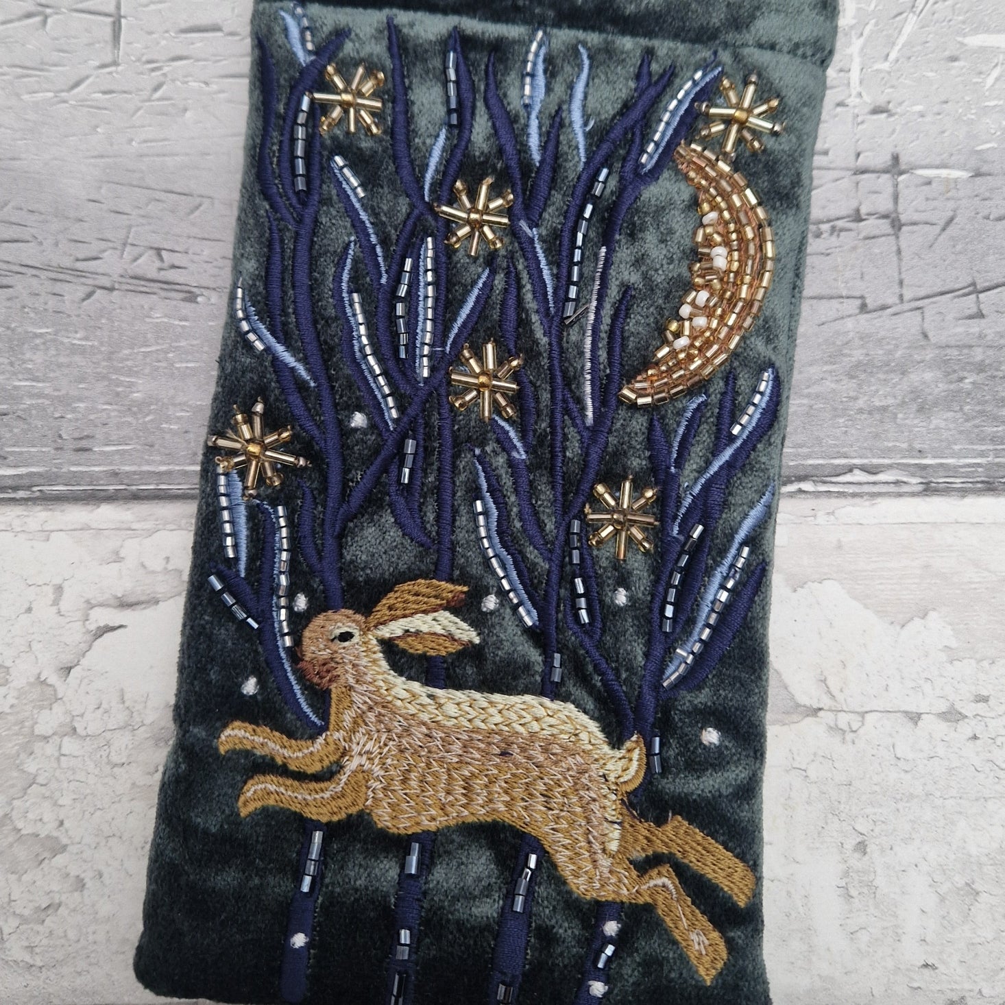 Dark grey velvet glasses case decorated with an embroidered Hare running through the woods under a crescent moon and starry night scene. Finished with beads and sequins.
