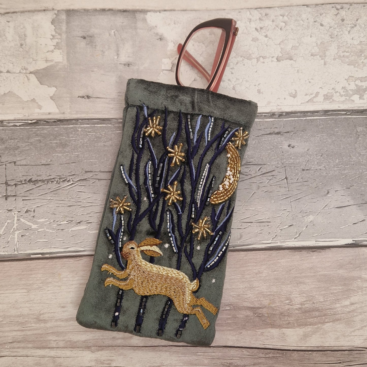Dark grey velvet glasses case decorated with an embroidered Hare running through the woods under a crescent moon and starry night scene. Finished with beads and sequins.