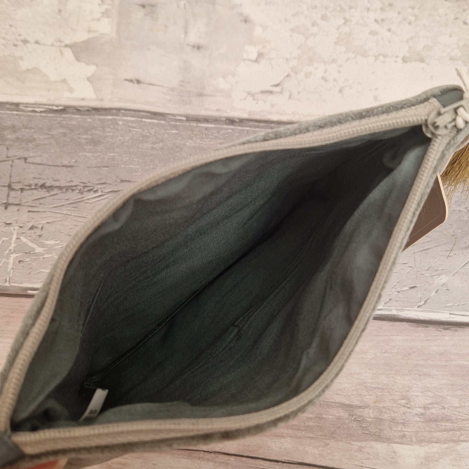 Open grey bag on a wooden surface