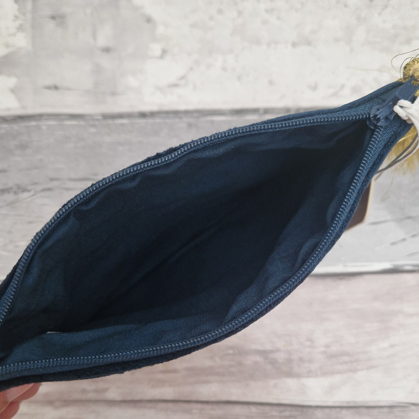 Open navy blue pouch on a wooden surface