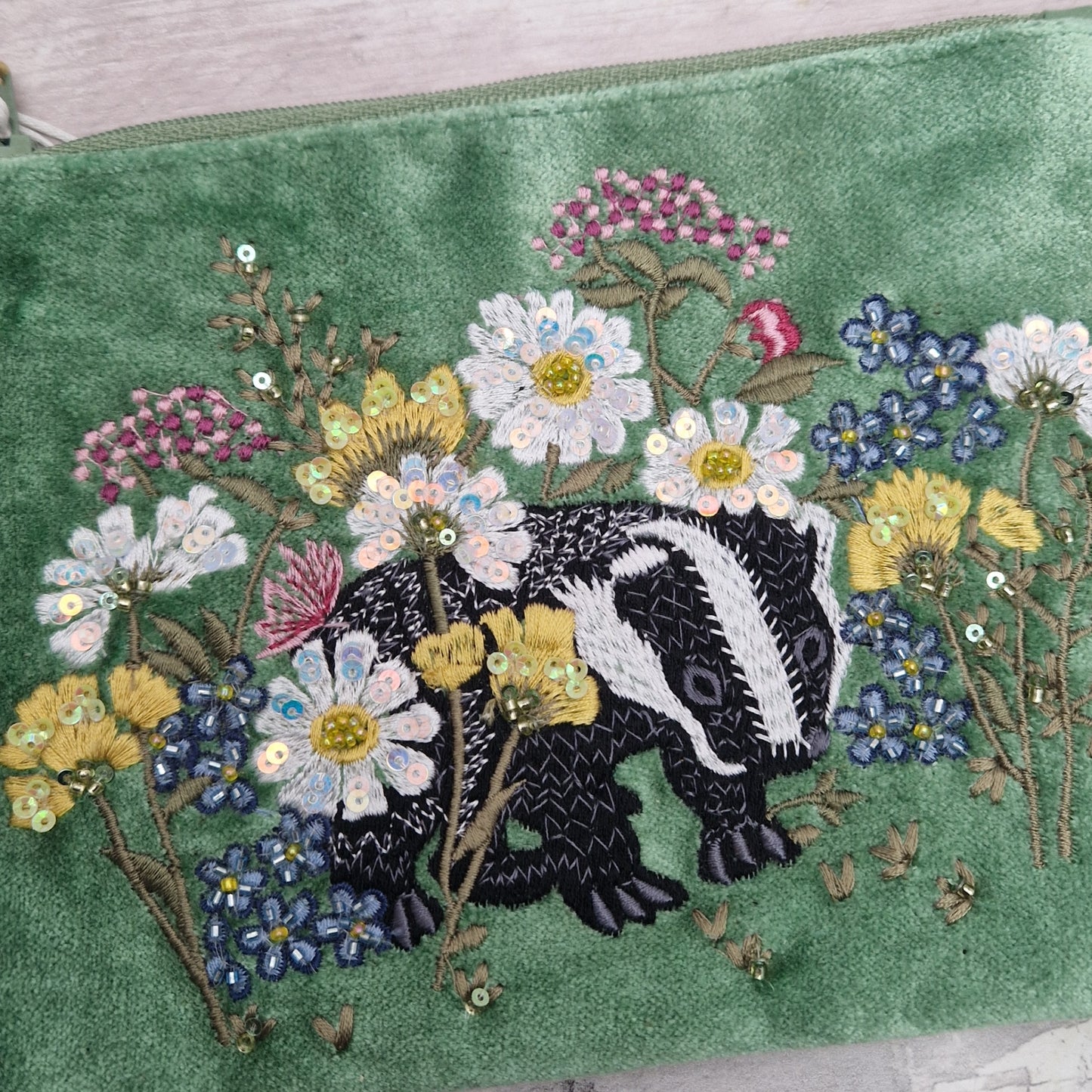 Green velvet pouch with embroidered badger and flowers finished with beads and sequins.