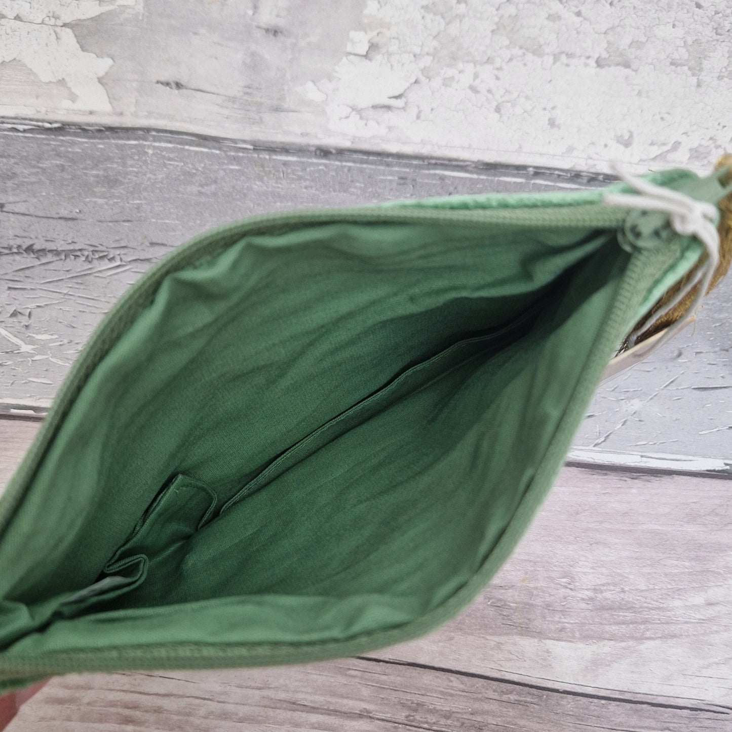 Green fabric pouch on a wooden surface