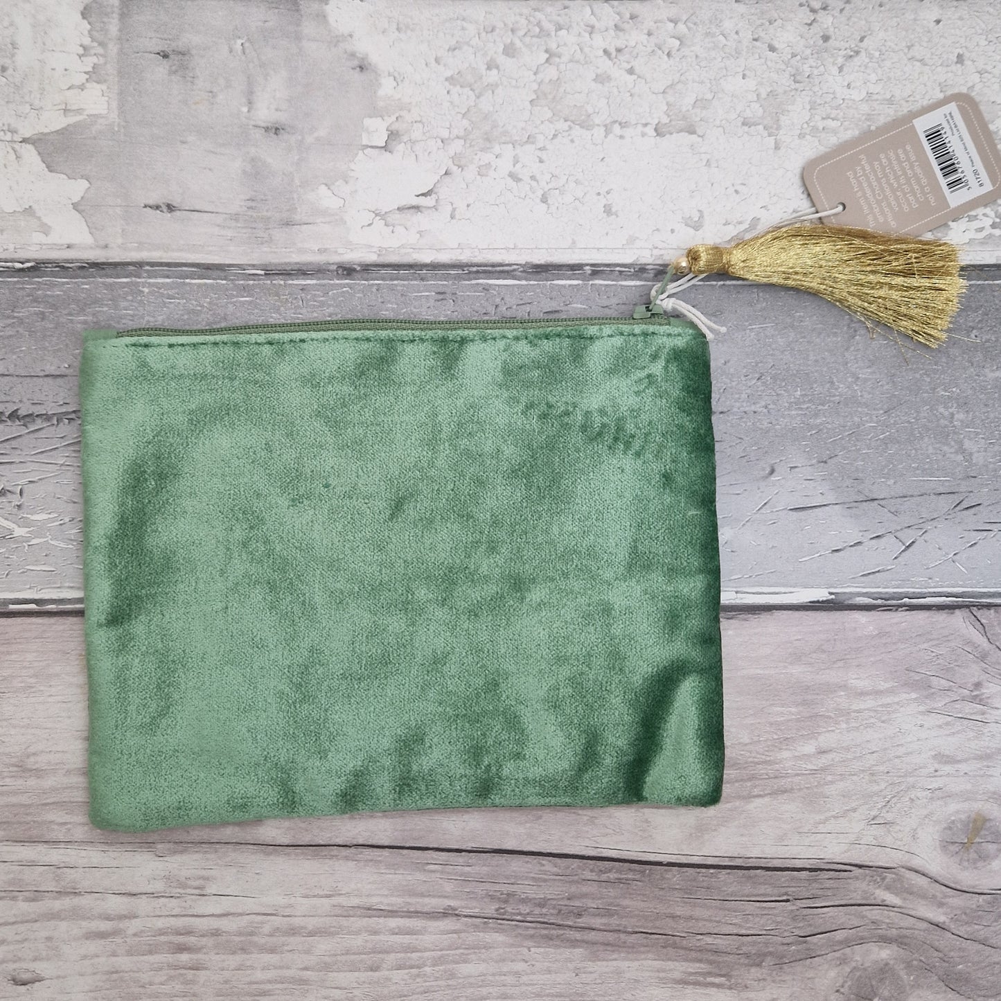 Green pouch with a tassel on a wooden surface