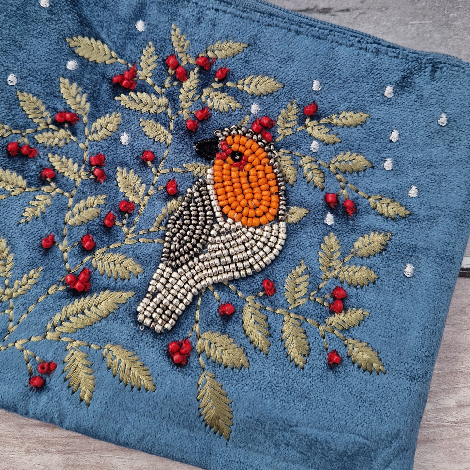 Dusky Blue Velvet Make up Bag decorated with an embroidery and bead design featuring a Robin surrounded by festive holly.