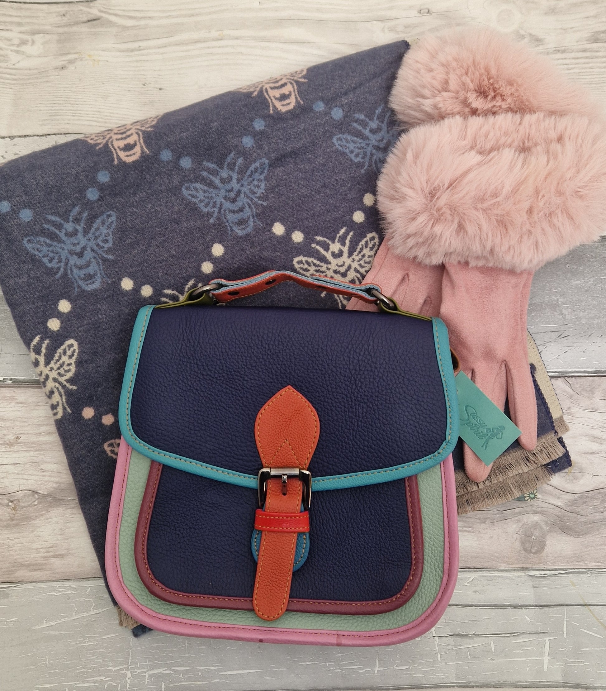Navy and pink accessories comprising a leather bag, scarf and gloves.