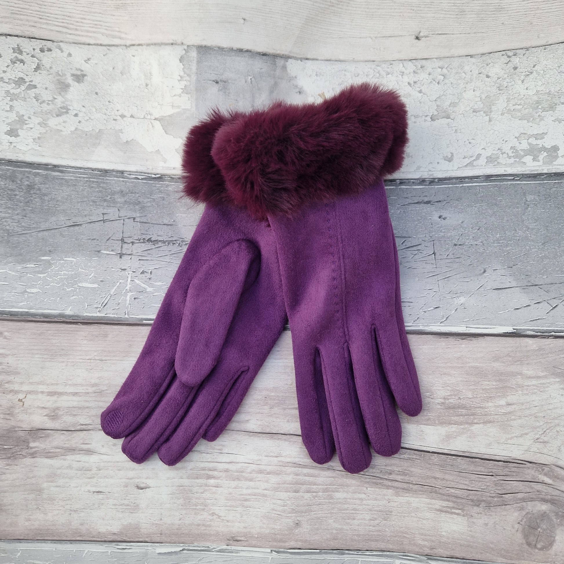 Purple coloured gloves with a faux fur trim and stitching detail down the back of the hand.