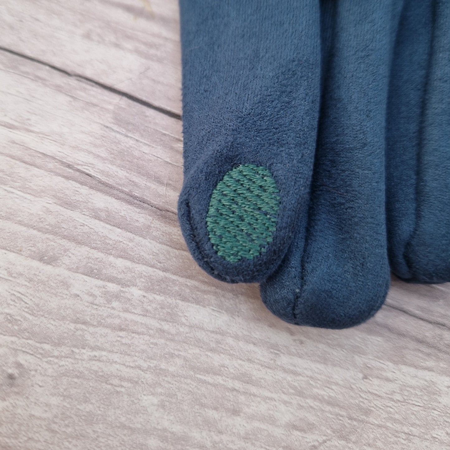 Textured pad on finger tip of glove.