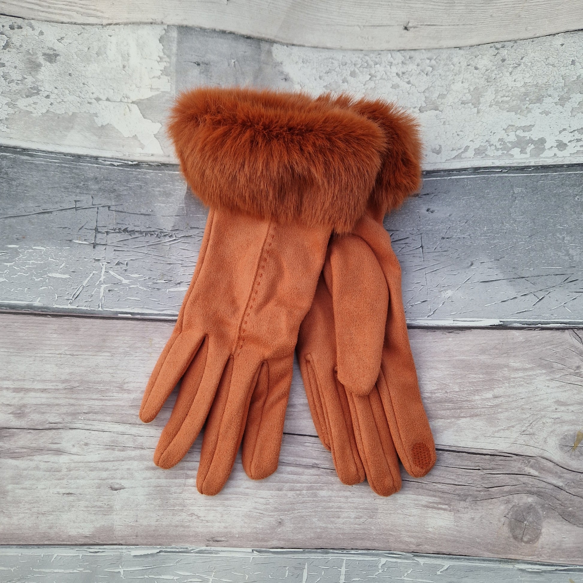 Orange coloured gloves with a faux fur trim and stitching detail down the back of the hand.