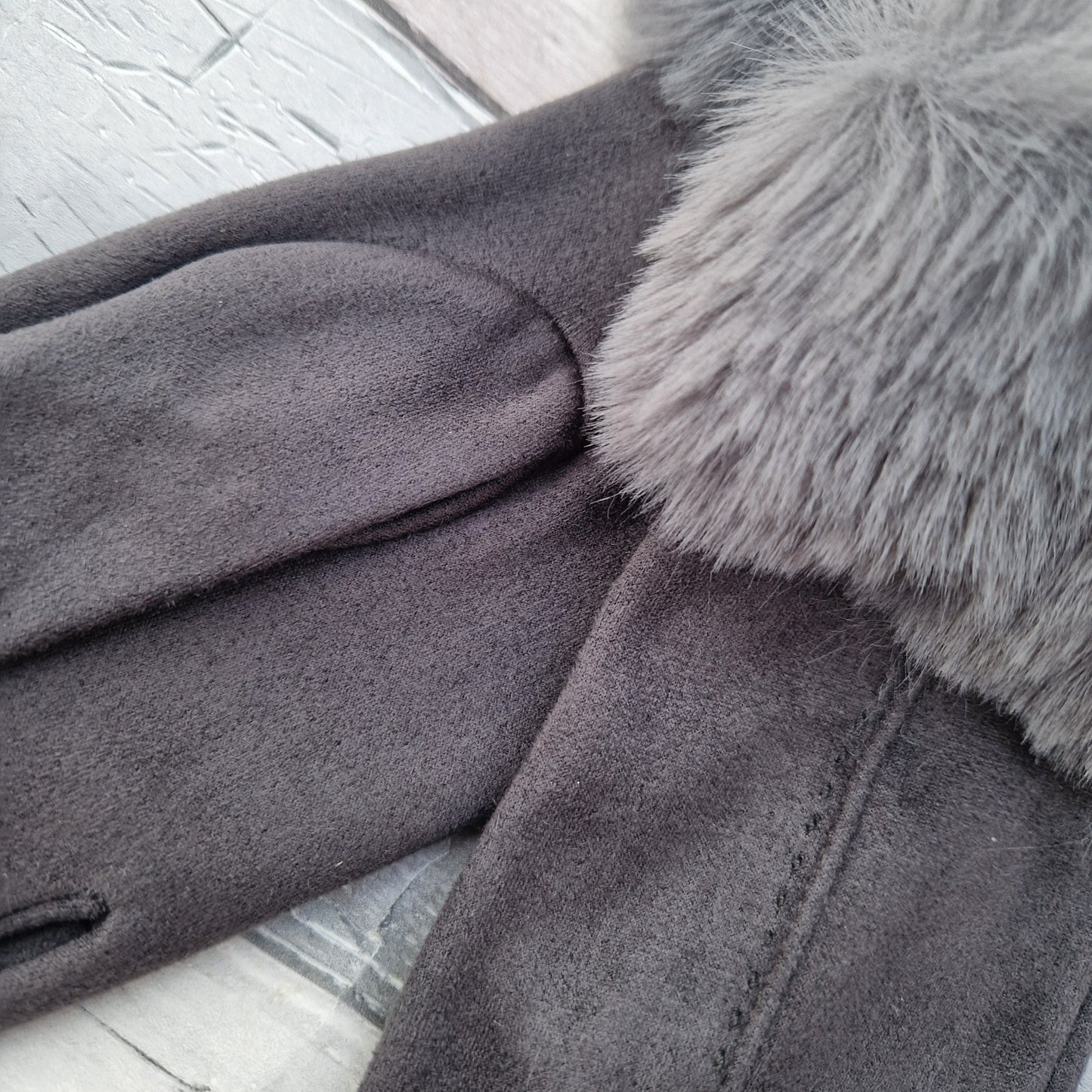 Dark Grey coloured gloves with a faux fur trim and stitching detail down the back of the hand.