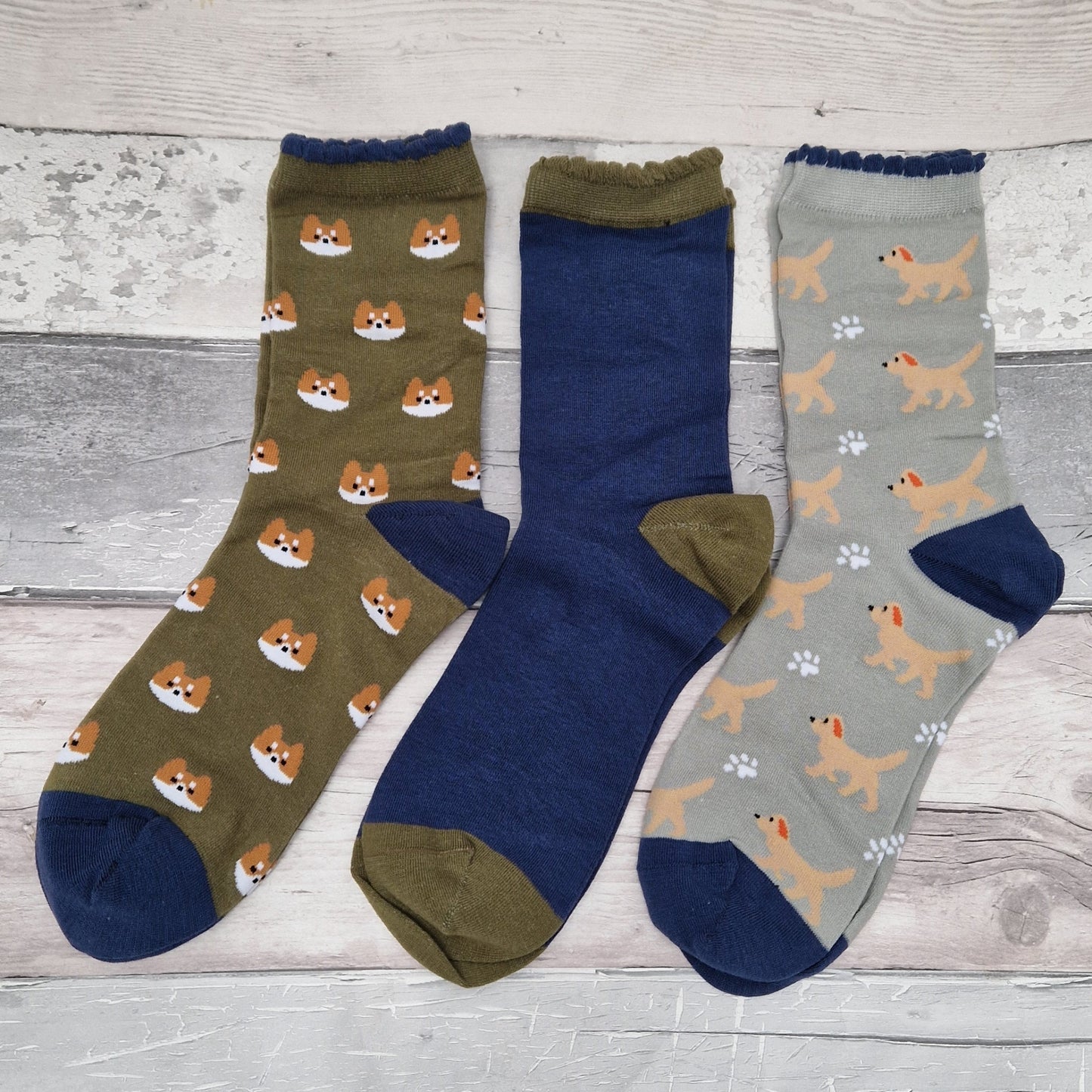 Three pairs of socks with dog patterns on a wooden surface