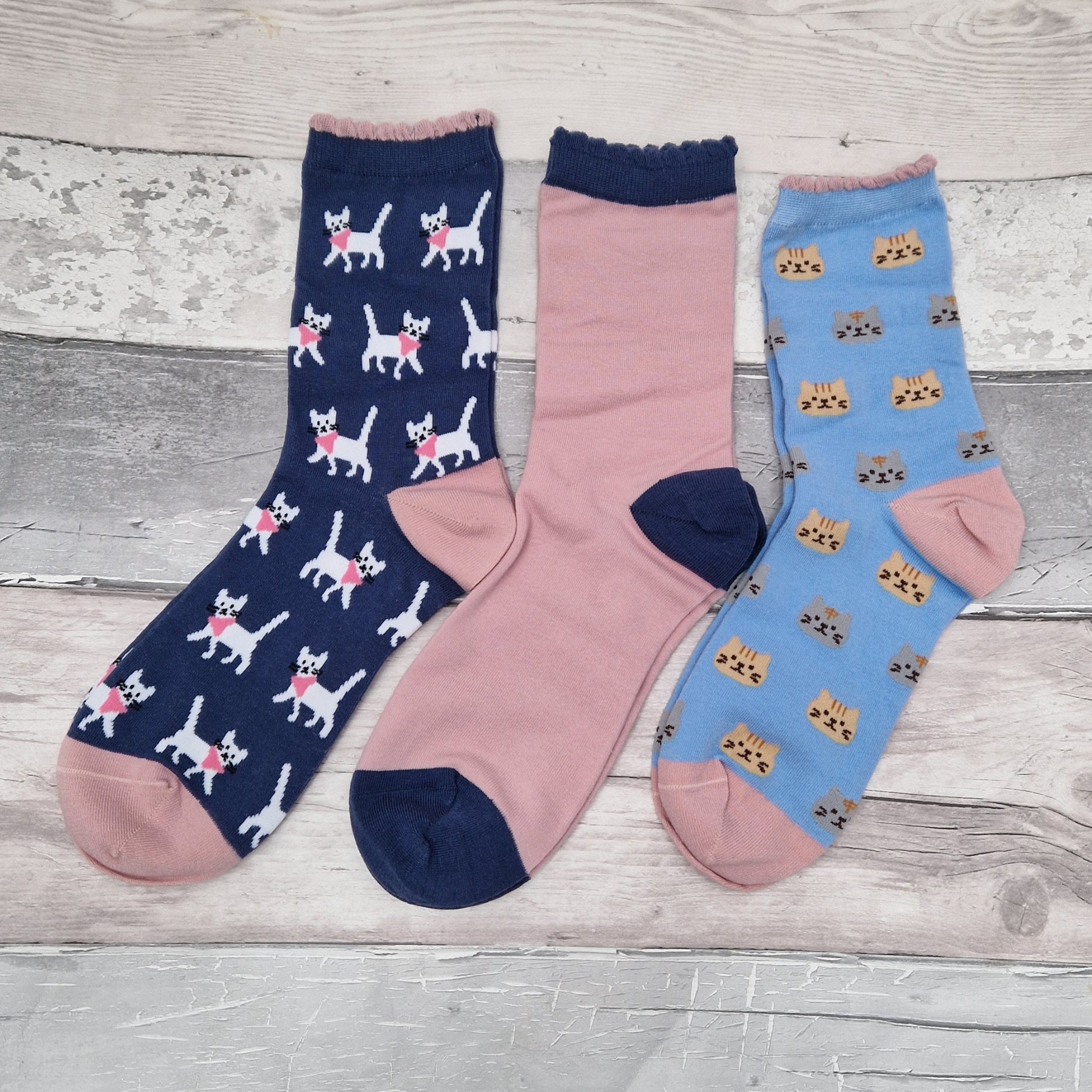 3 Pairs of pink and blue socks with cat decoration.