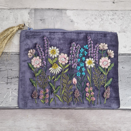 Purple velvet pouch decorated with embroidered flowers. Finished with hand sewn beading.