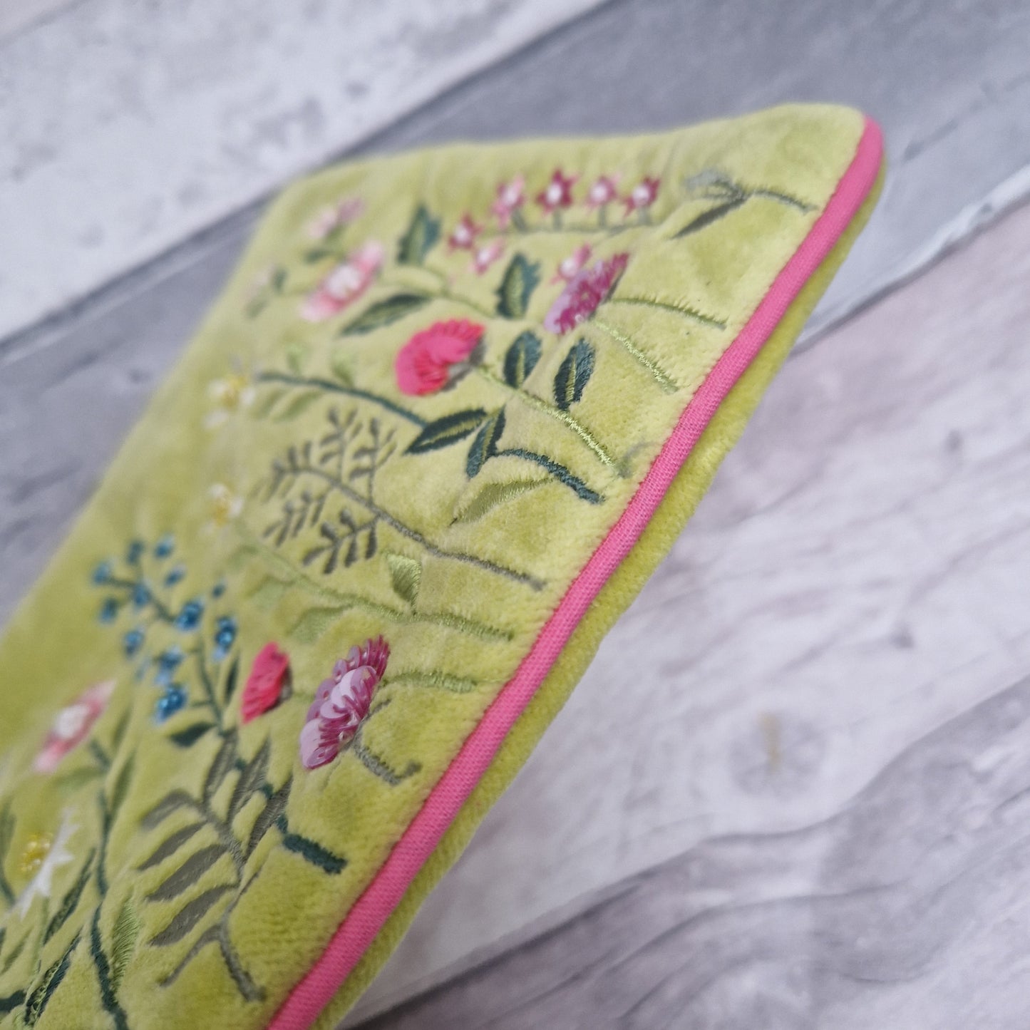 Lime velvet pouch decorated with embroidered flowers. Finished with hand sewn beading and pink piping.