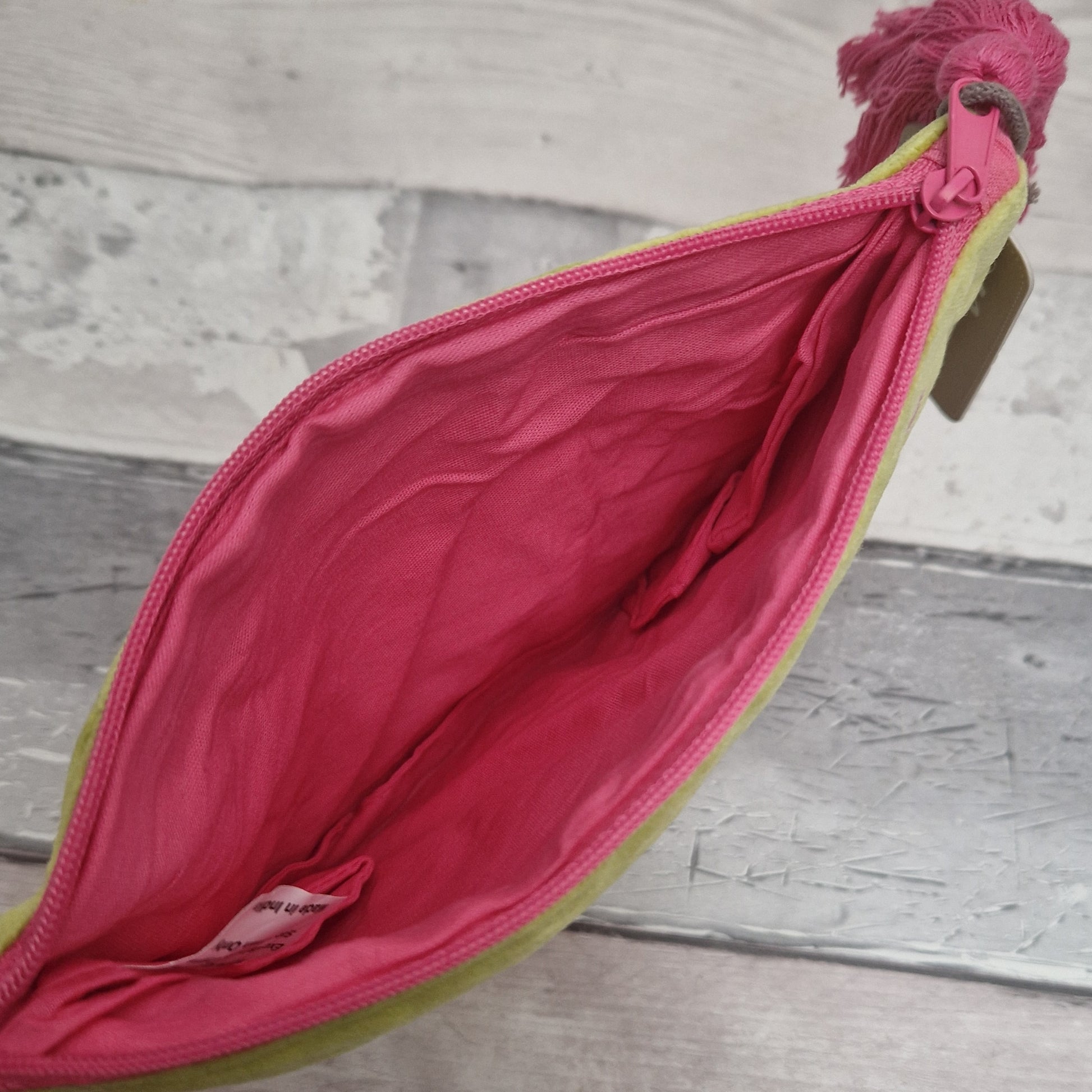 Inside view of lime velvet pouch showing a pink lining.
