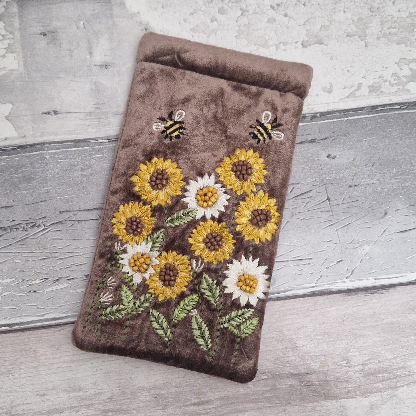 Brown coloured velvet glasses case decorated with embroidered sun flowers and bees. Finished with hand sewn beads.