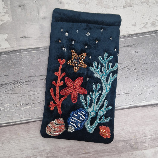 Navy coloured velvet glasses case decorated with underwater scene featuring coral, sea shells and star fish. Finished with hand sewn beads.