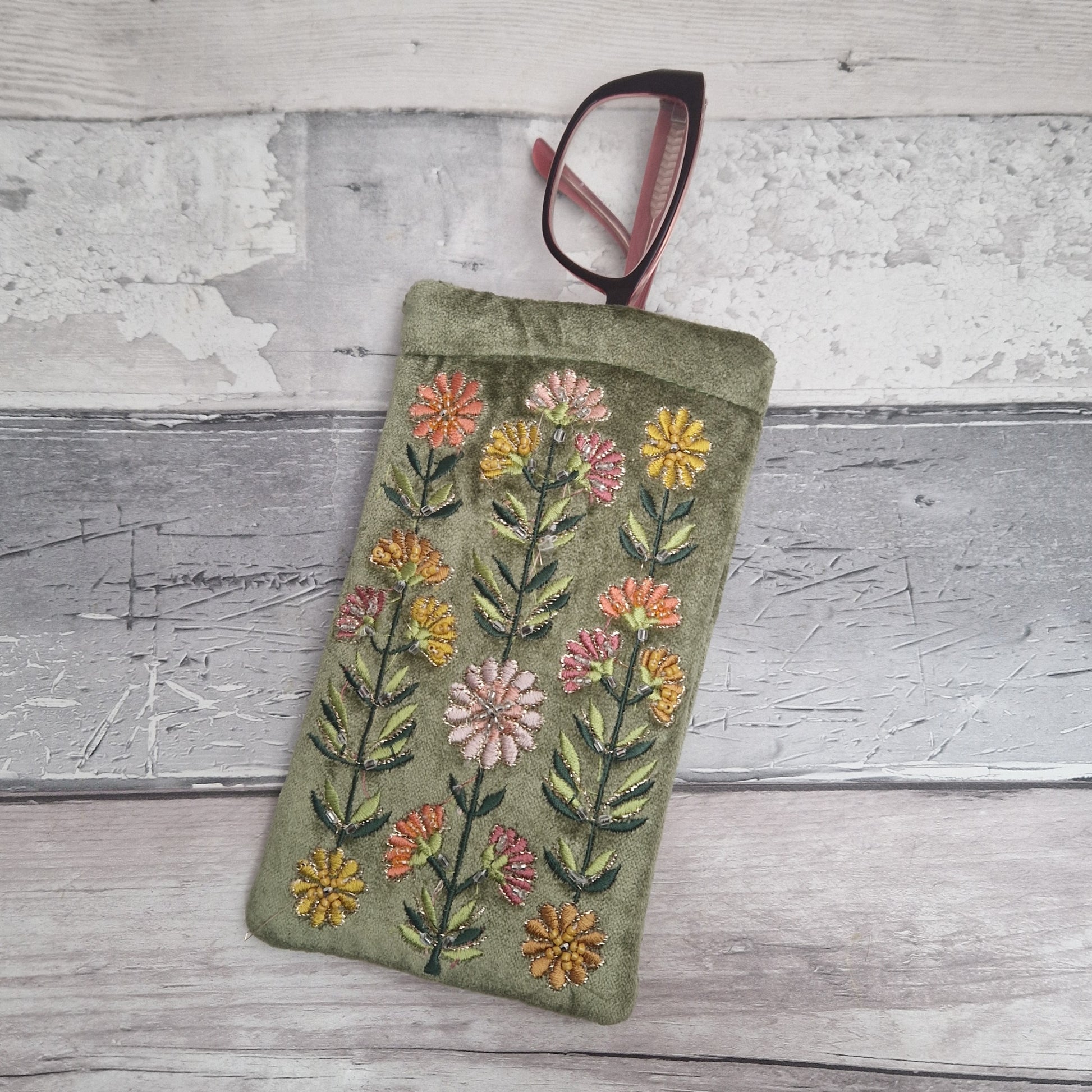 Green coloured velvet glasses case decorated with Gerbera flowers. Finished with hand sewn beads and metallic thread.