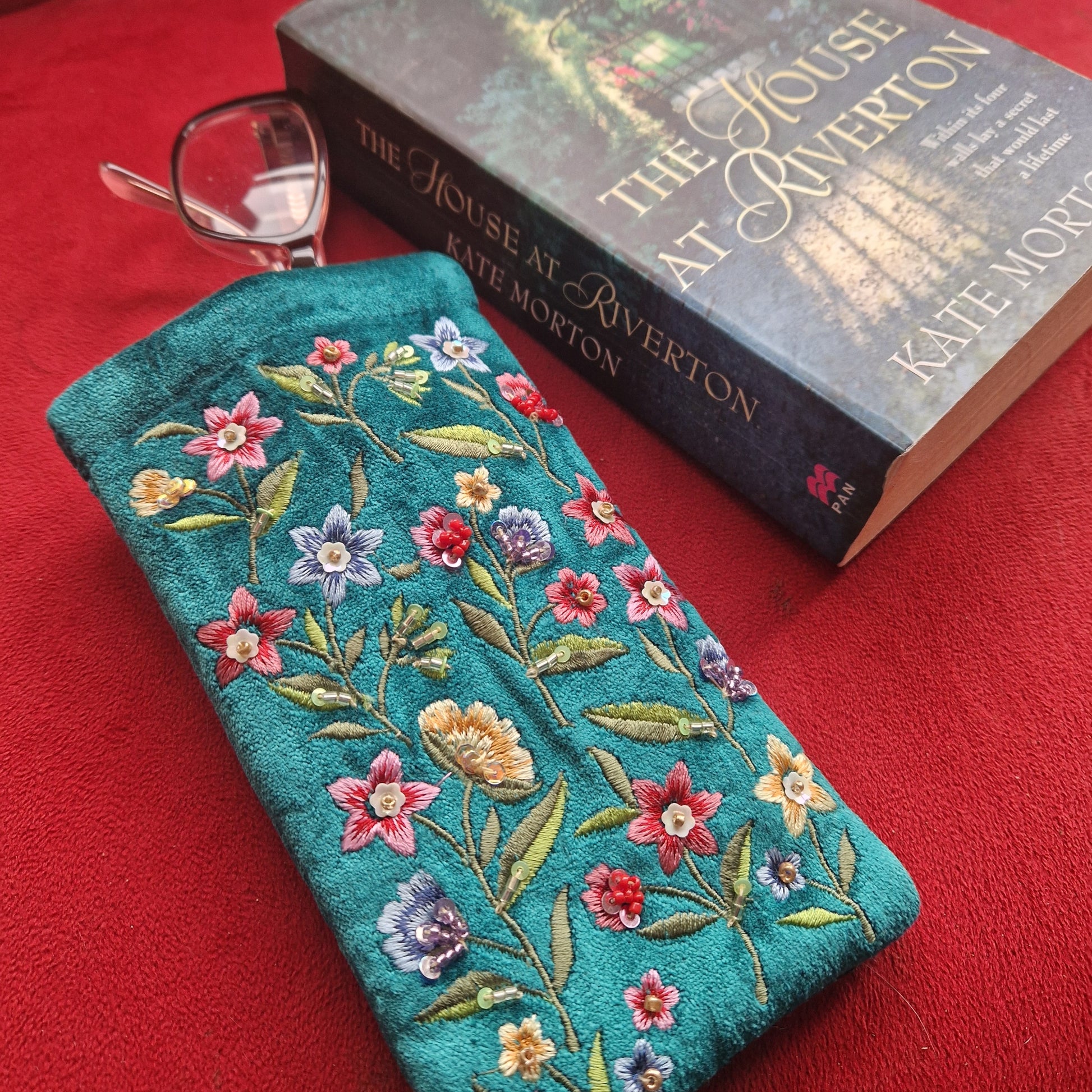 Turquoise coloured velvet glasses case decorated with embroidered wildflowers in red, yellow and blue on green stems. Finished with hand sewn sequins and beads.