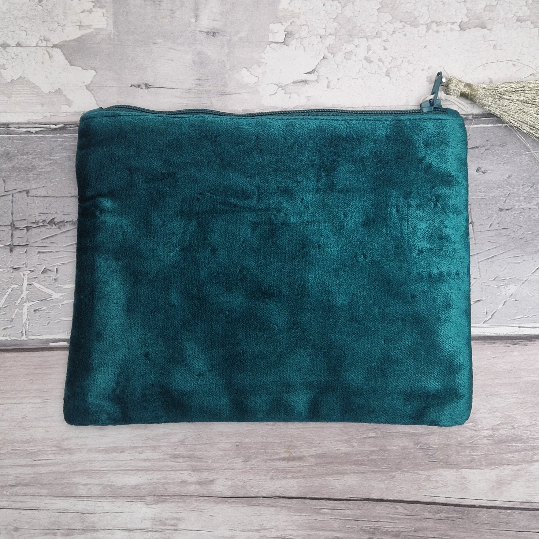Turquoise coloured velvet pouch decorated with embroidered wildflowers in red, yellow and blue on green stems. Finished with hand sewn sequins and beads.