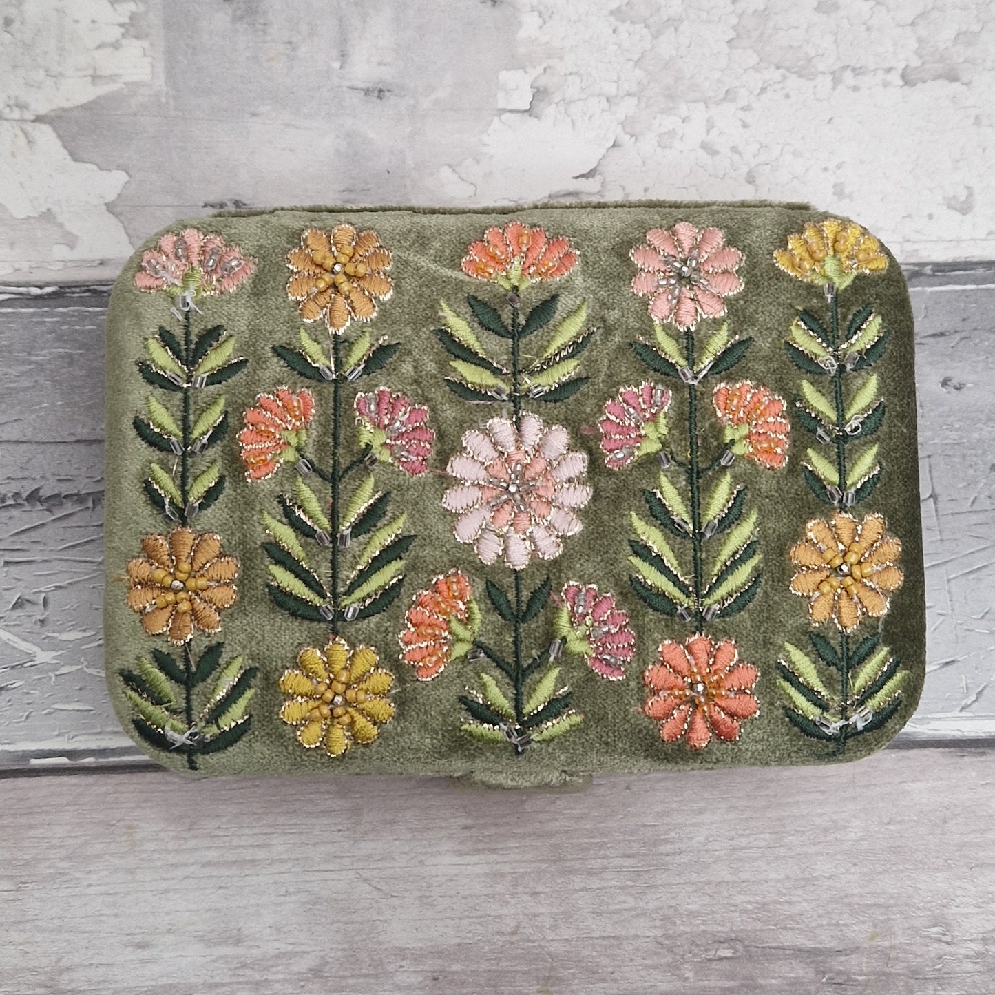 Green coloured velvet jewellery box decorated with embroidered Gerbera flowers in pink, yellow and orange on green stems. Finished with hand sewn sequins and metallic thread.