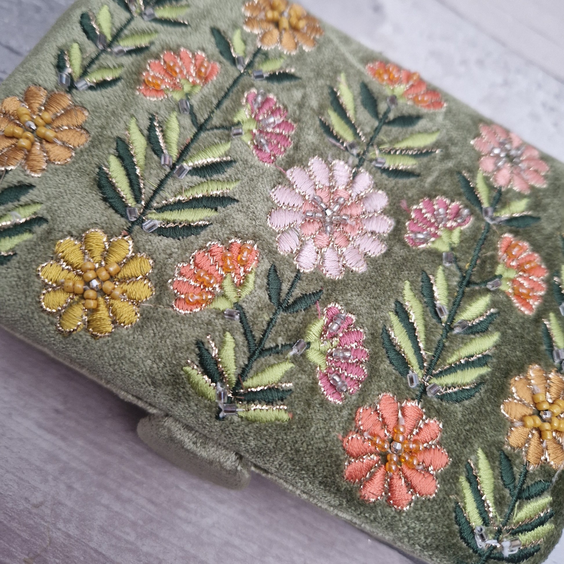 Green coloured velvet jewellery box decorated with embroidered Gerbera flowers in pink, yellow and orange on green stems. Finished with hand sewn sequins and metallic thread.