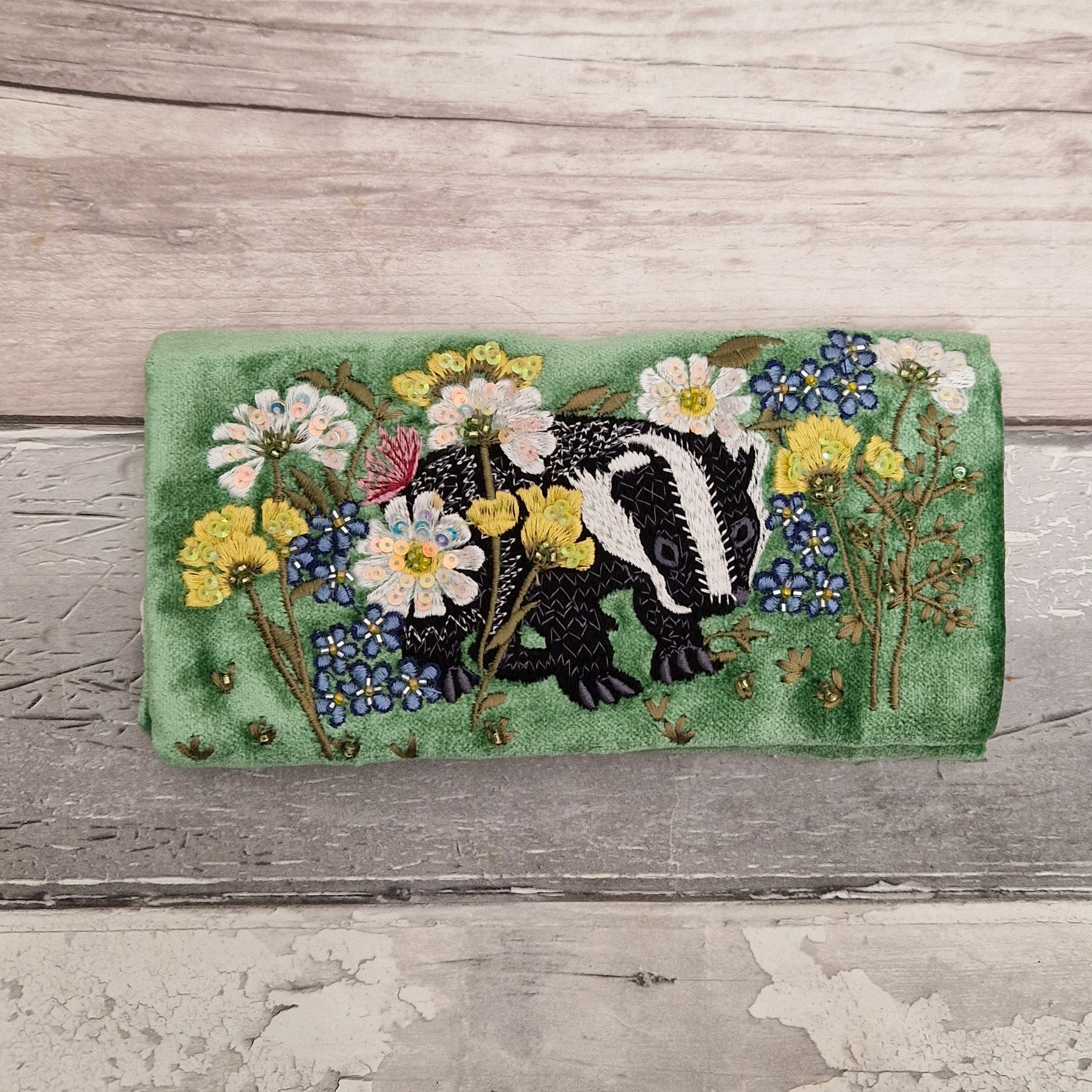 Green Velvet Jewellery Roll decorated with embroidered badger amongst flowers finished with beading and sequins.