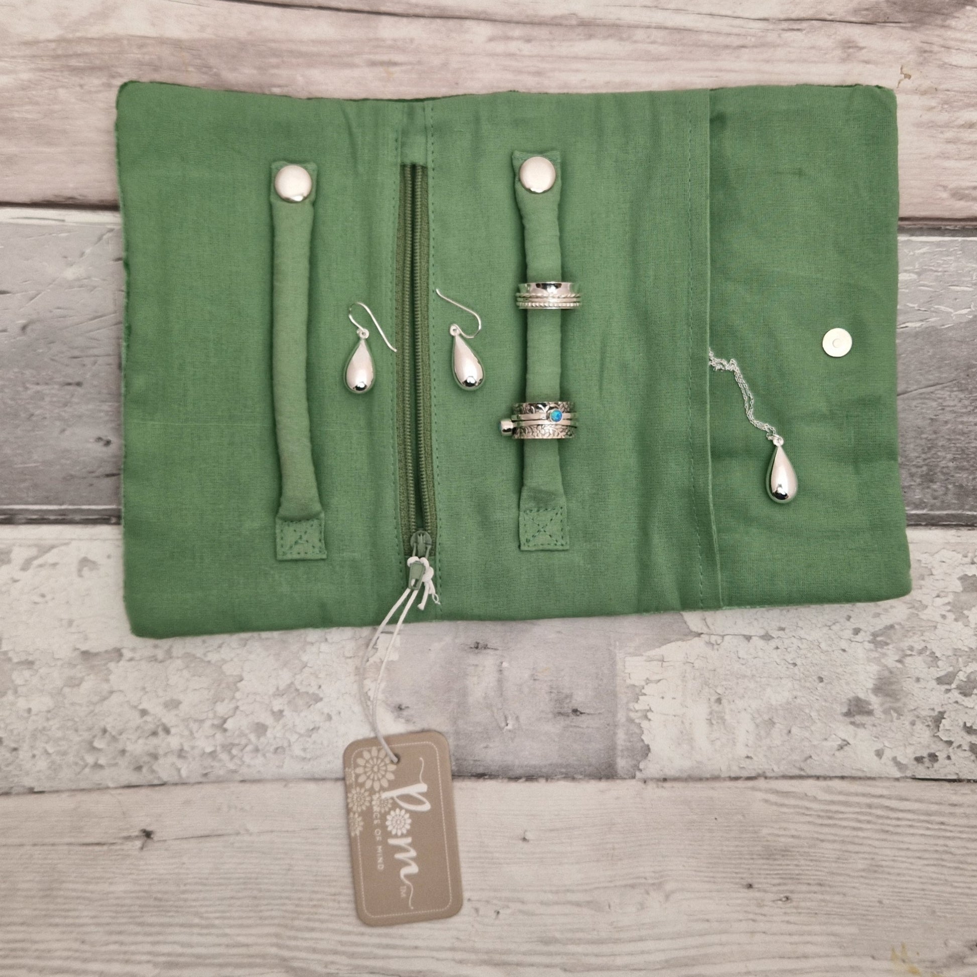 Inside view of an open jewellery roll with silver jewellery ready for storage.
