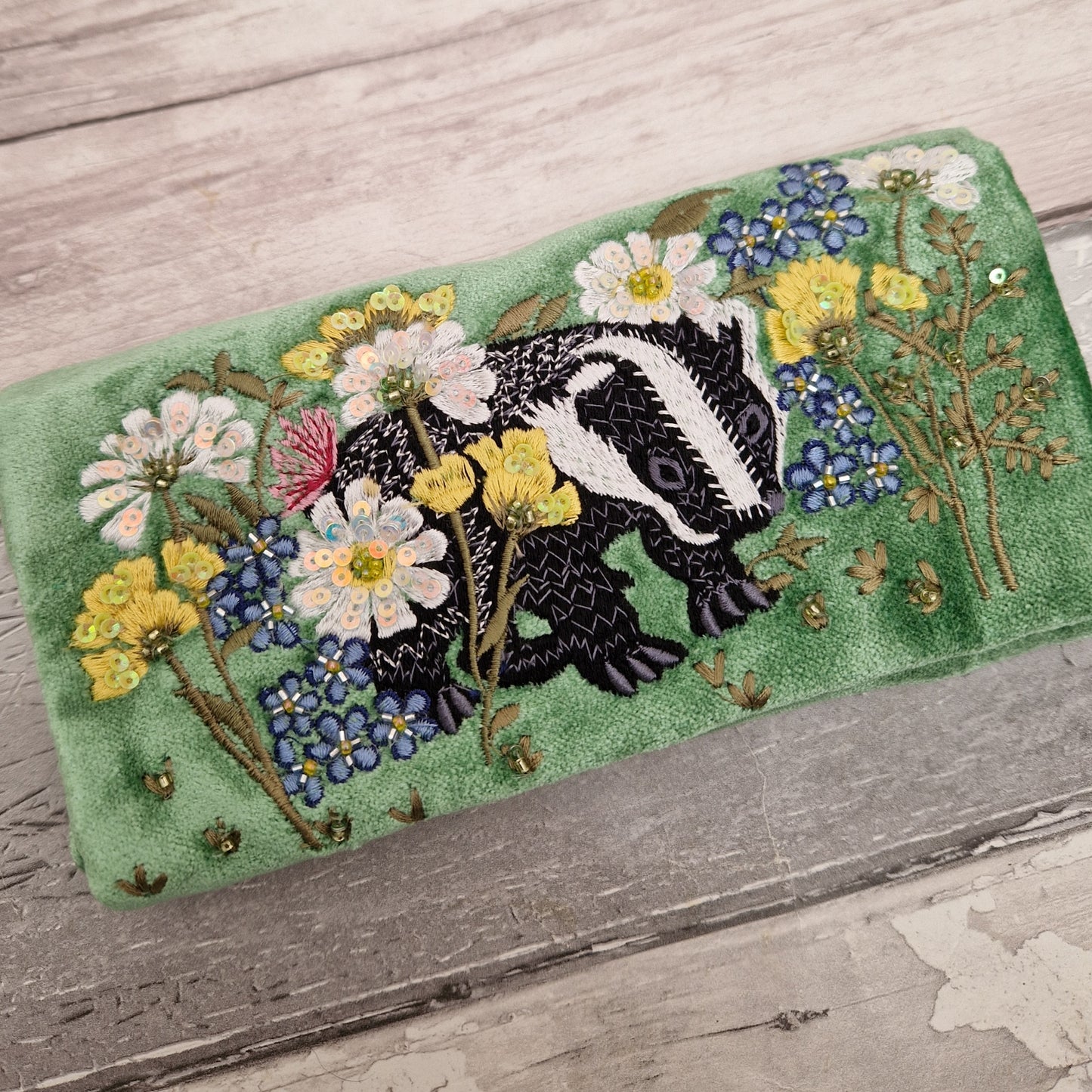 Green Velvet Jewellery Roll decorated with embroidered badger amongst flowers finished with beading and sequins.