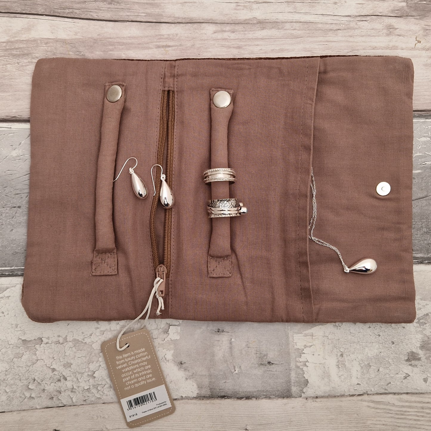 Inside view of an open jewellery roll with silver jewellery ready for storage.