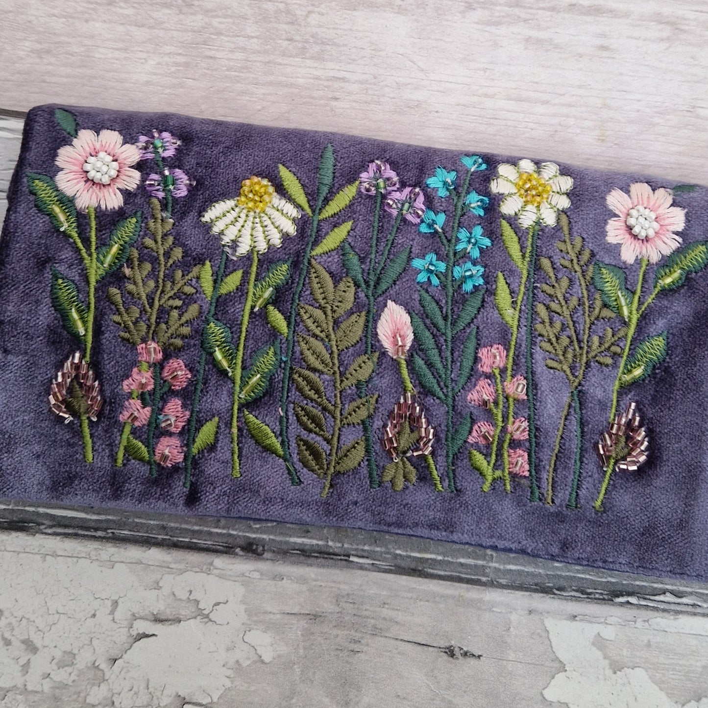 Purple Velvet Jewellery Roll decorated with embroidered flowers finished with beading.