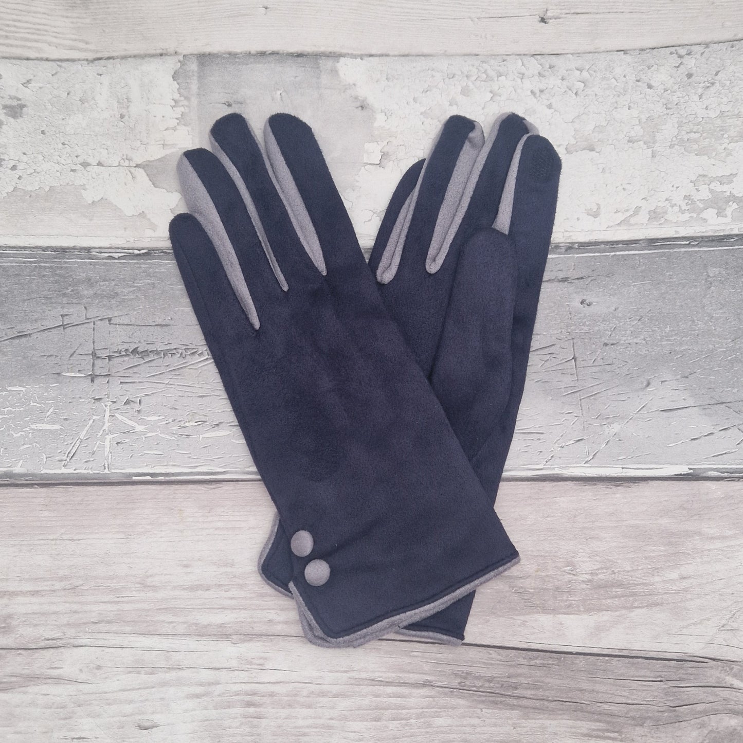 Navy and grey coloured gloves with grey buttons presented in a black gift box.