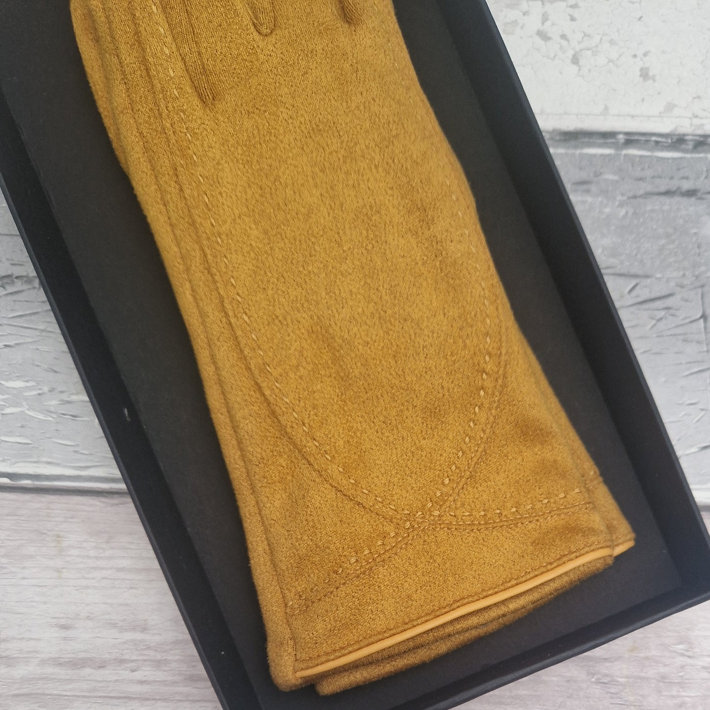 Brown suede feel glove in a black presentation gift box.
