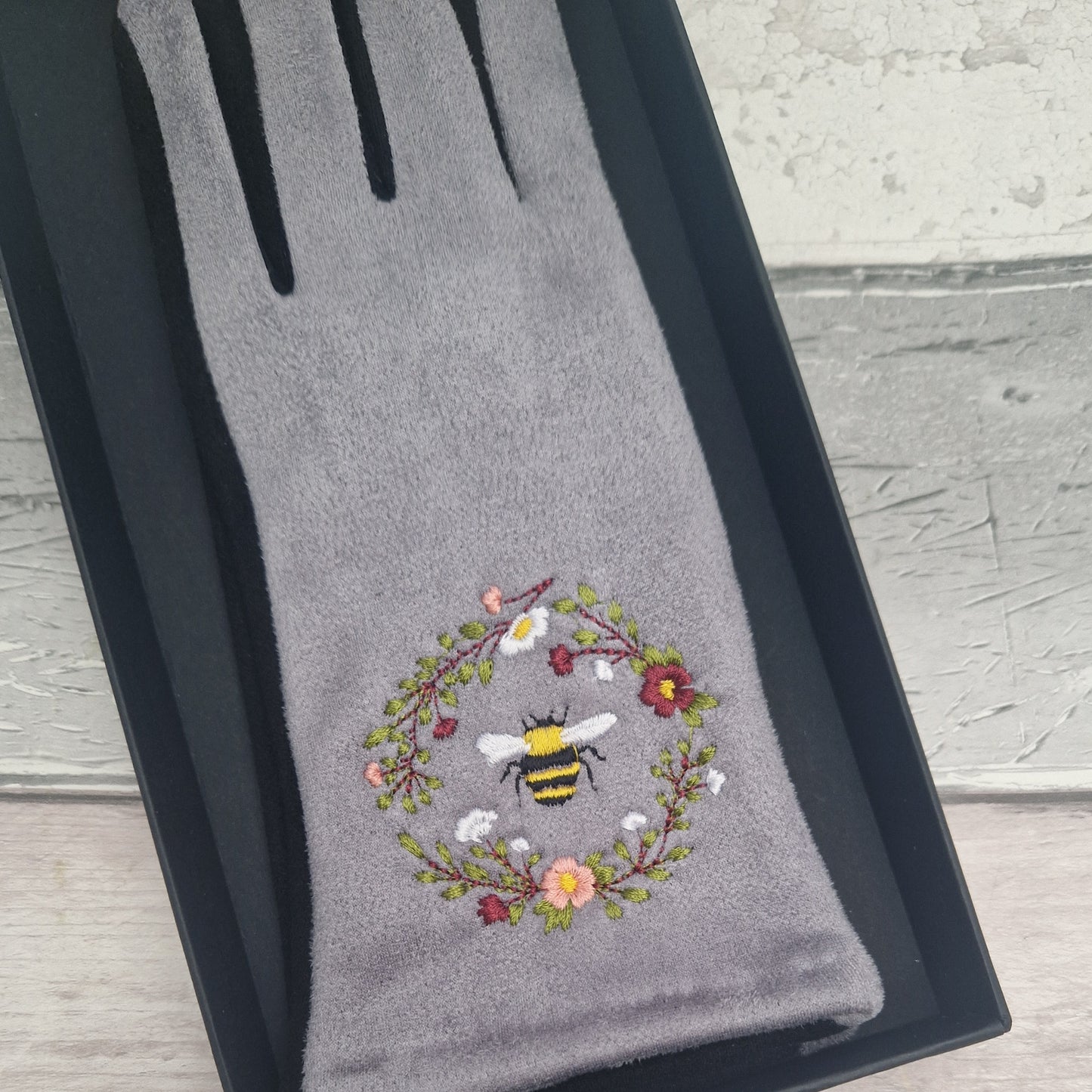 Grey and Black two tone gloves with an embroidered bee design in a gift box.