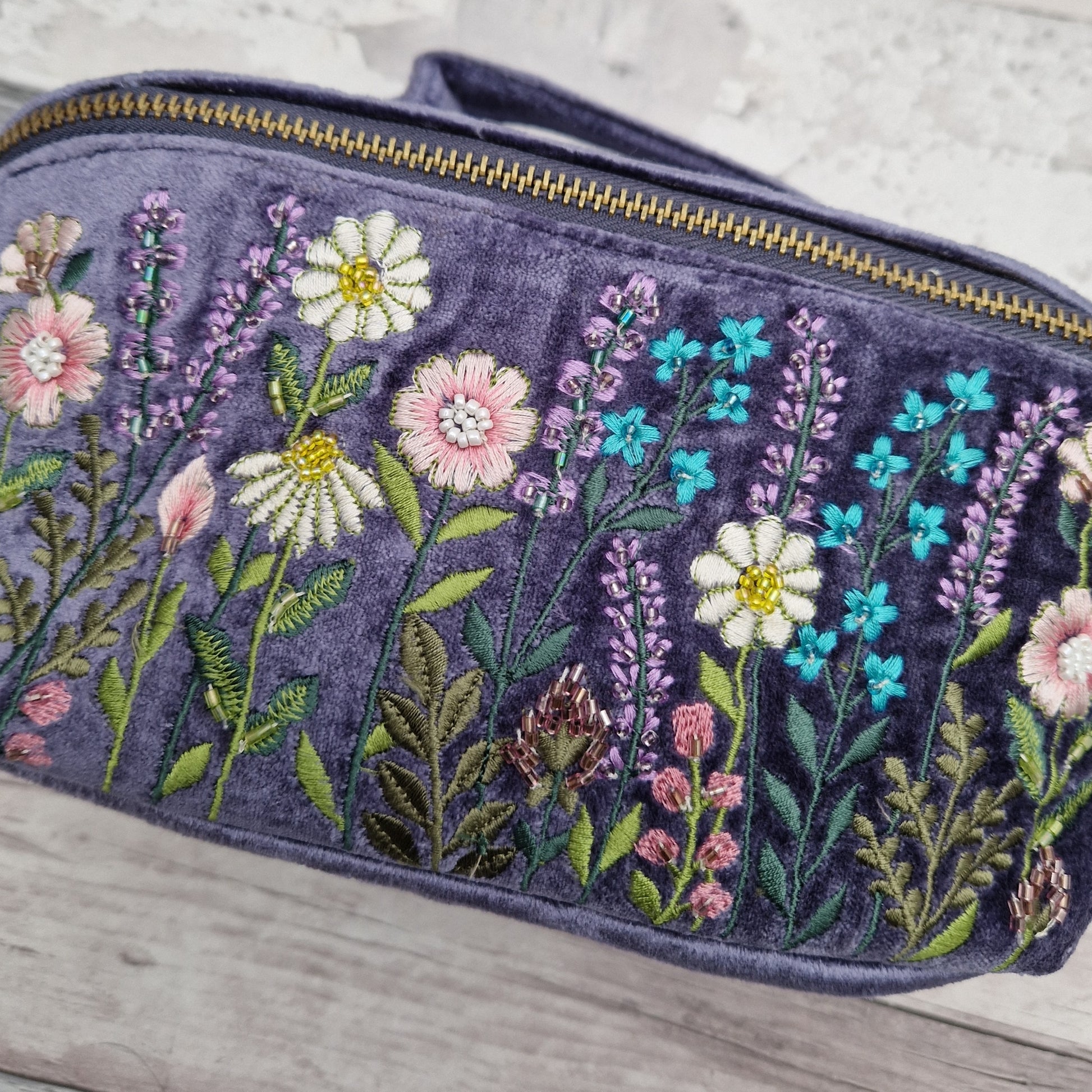 Close up view of embroidery - wildflowers on a purple velvet back ground.