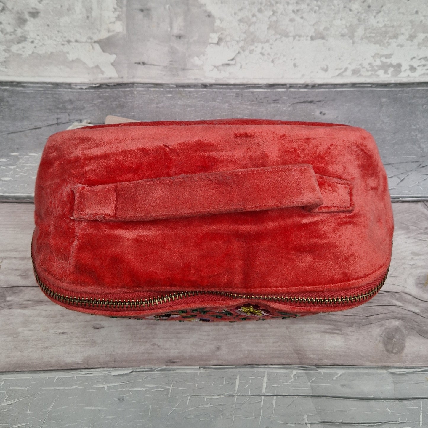 Top view of salmon coloured velvet vanity case showing top carry handle.